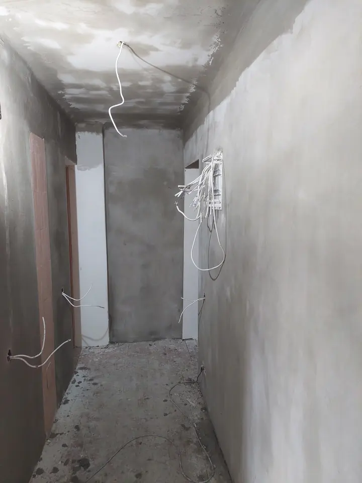 Šaurs gaitenis pēc apmešanas, no sienām vēl nāk vadi.