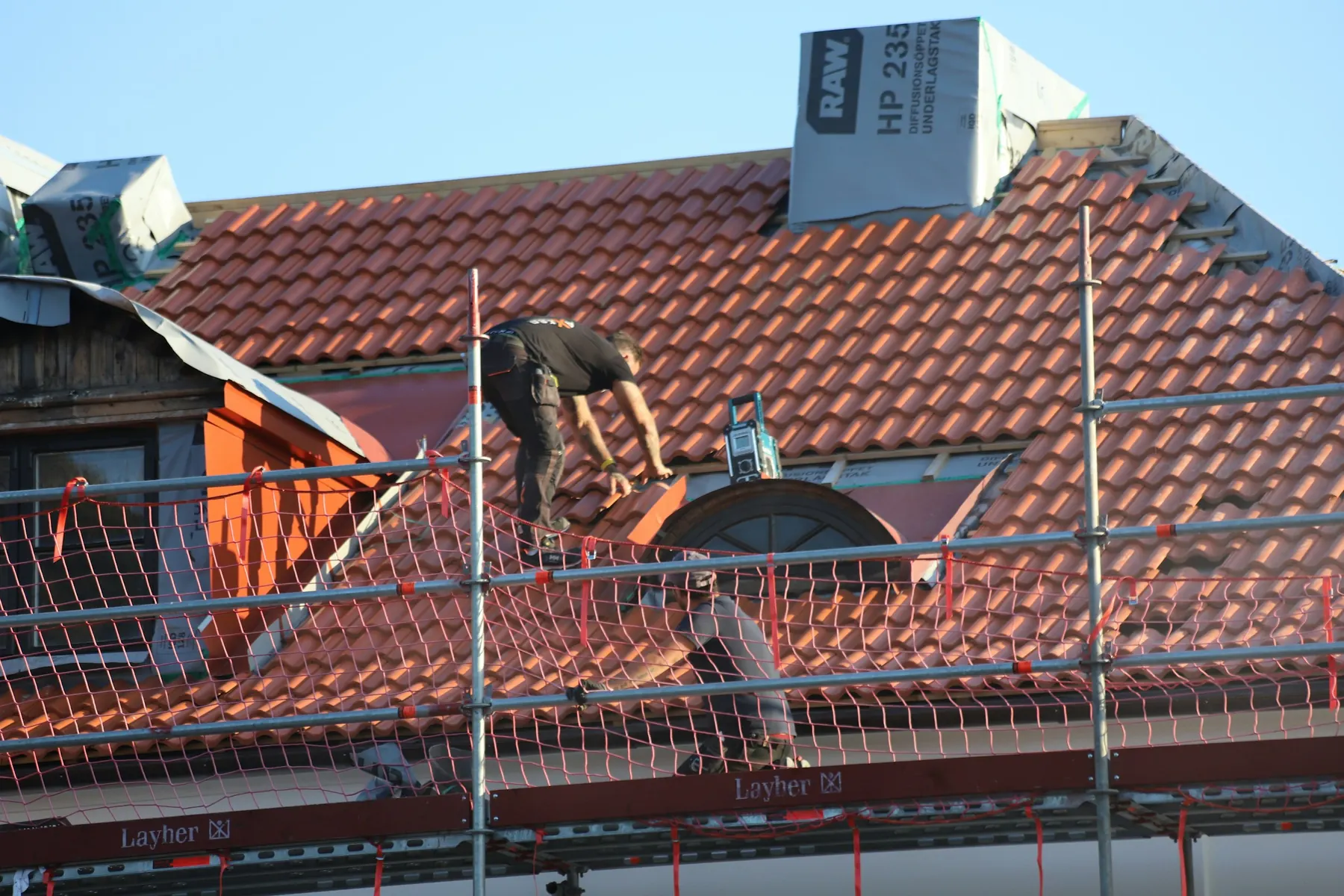 Fachkraft bei Arbeiten an einem Ziegeldach