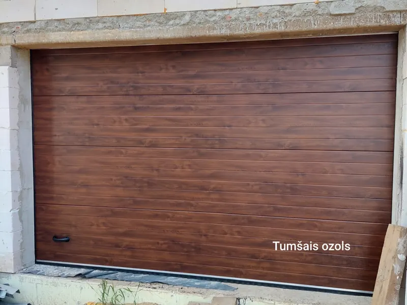 Sekciju garāžas vārti ar tumšā ozola imitāciju, rievotu paneli un rokturi